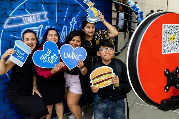 Group of 第一总务室 students pose for a selfie with 威尼斯人娱乐城 signs at a coffee connection event