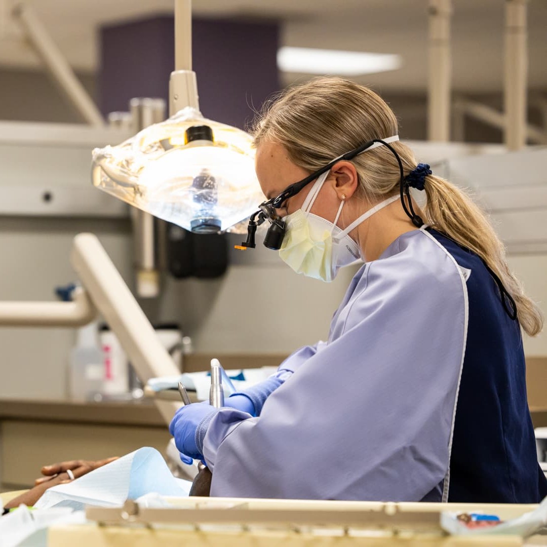 A group of students laugh while standing on the rooftop of the Barkley advertising agency. The 堪萨斯城 skyline is seen behind them.