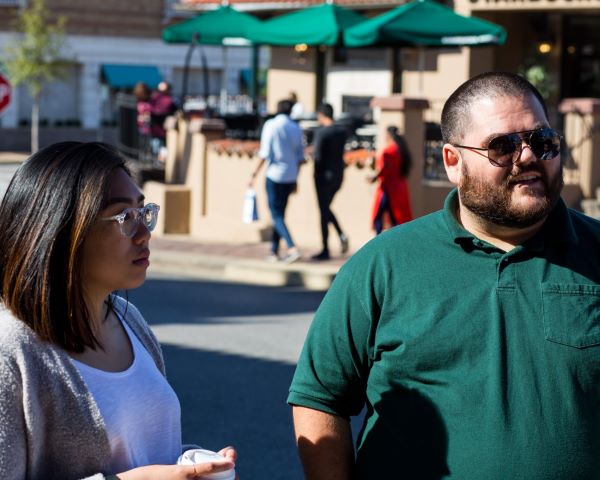 Two international students walk on the sidewalk on the KC Plaza