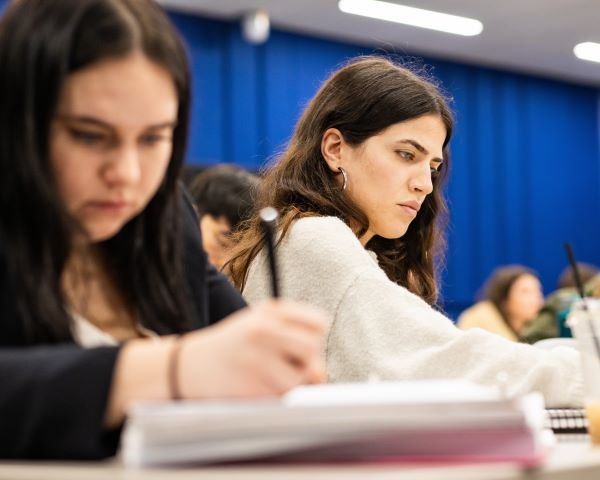 two students take notes in constitutional law class