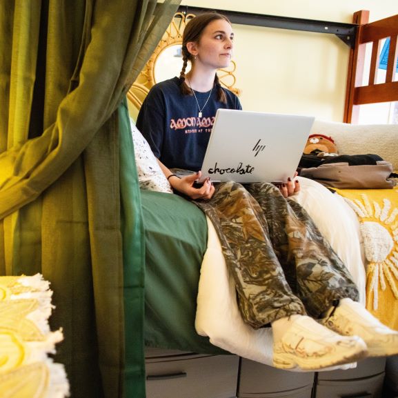 Three nursing students stand around an electronic table that simulates a body for anatomy class