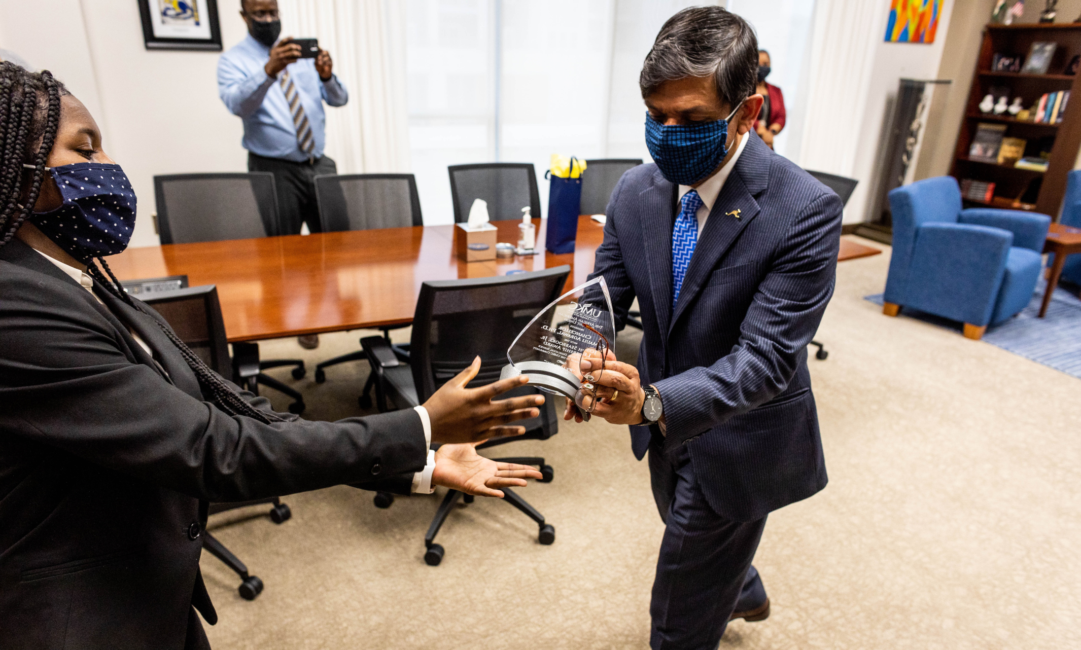 Student Brenda Reed presents award to Chancellor