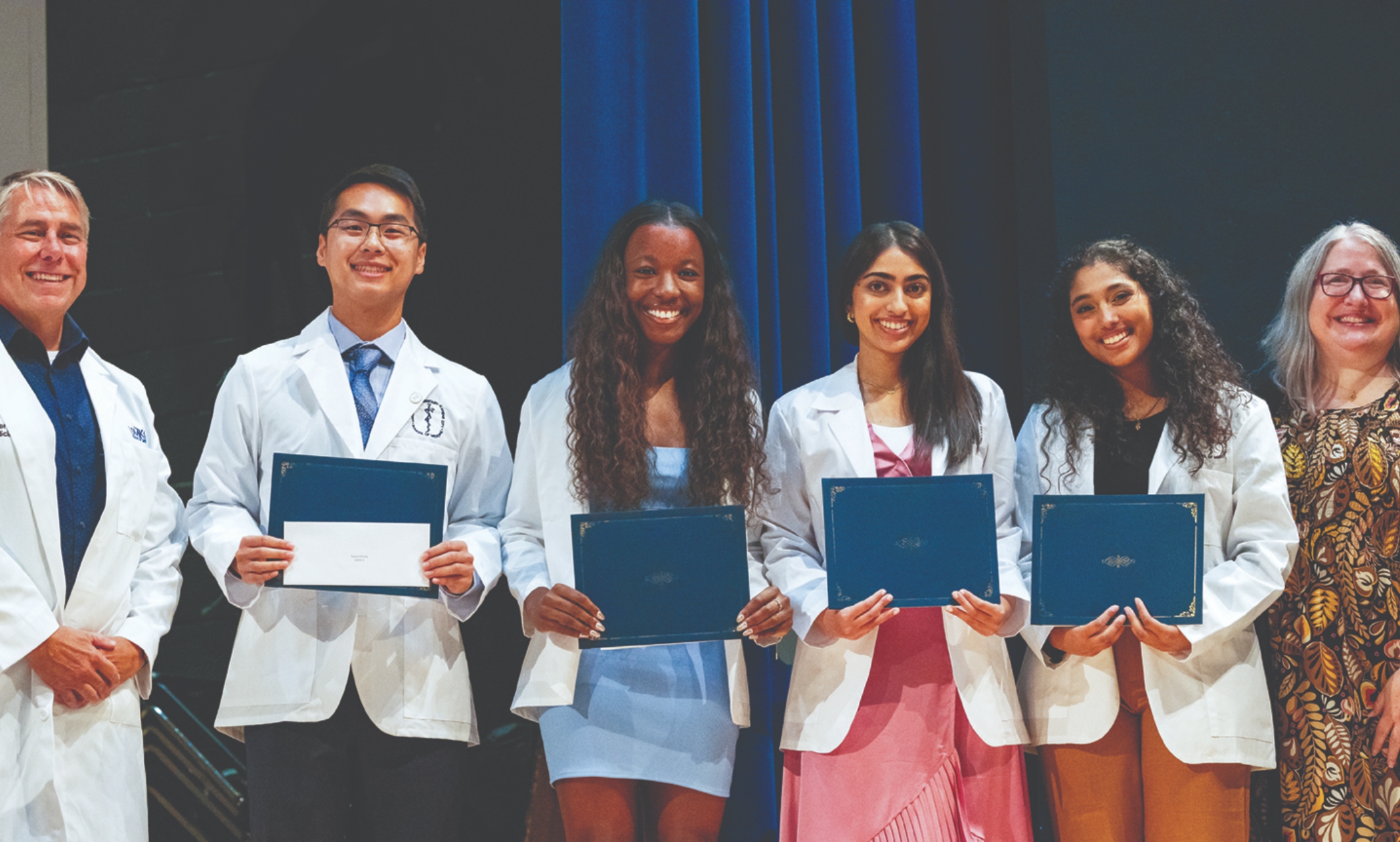 Students dressed in white coats