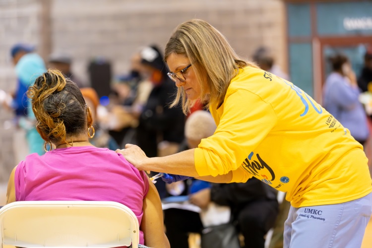 A person gives ano的r person a vaccination