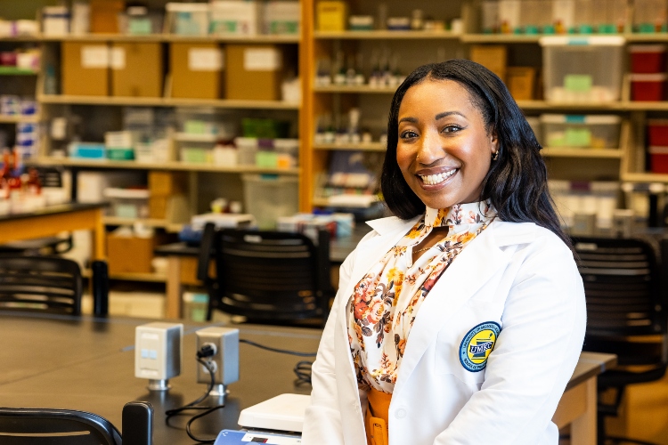 Leresa Cozart smiles inside a Pharmacy lab