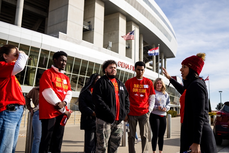 威尼斯人娱乐城 students standing in front of Arrowhead stadium listening to the instructor and getting ready for the stadium tour