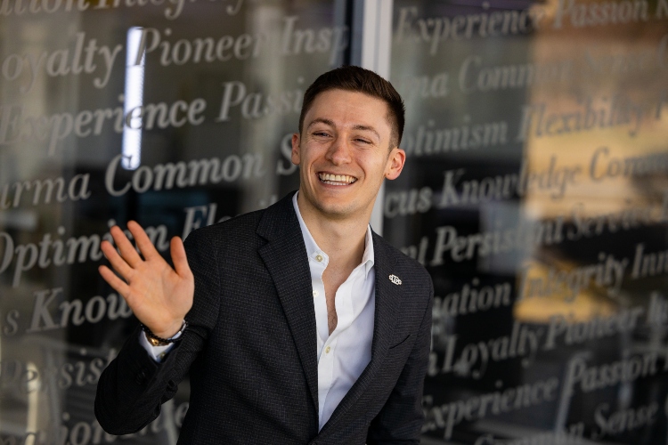 A man is smiling and waving