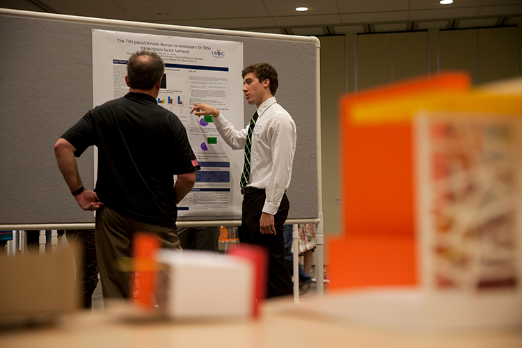 Student presenting research with a science model in the foreground