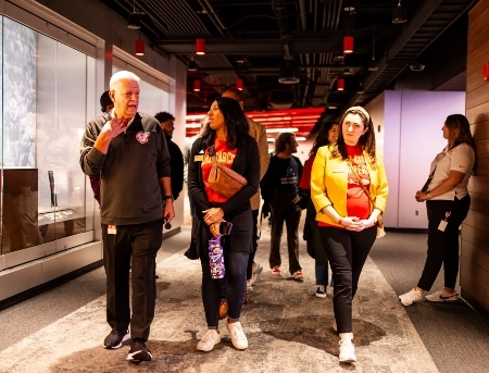 威尼斯人娱乐城 students walk down a hallway in Arrowhead stadium as they listen to a Chiefs historian on a tour of the stadium.