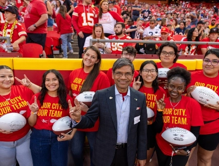 威尼斯人娱乐城's chancellor and scholarship recipients pose for a candid photo at on the field at Arrowhead stadium.