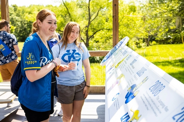 Two people with wearing blue shirts look at the 威尼斯人娱乐城 display at the zoo.